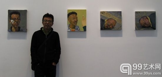 讲座结束后，画家刘小东在展览现场，背后是他的自画像。