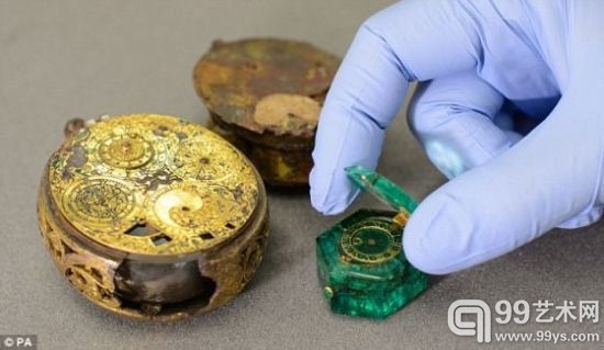伦敦博物馆的一名管理员打开哥伦比亚祖母绿手表的盖子，镀金黄铜表盘清晰可见。这个手表是齐普赛宝藏的一部分，将在伦敦博物馆展出。齐普赛宝藏是世界上最大的伊丽莎白一世时代和斯图亚特王朝早期珠宝宝藏之一