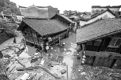 7月16日，凤凰古城内街道被水淹没，漂浮着杂物。