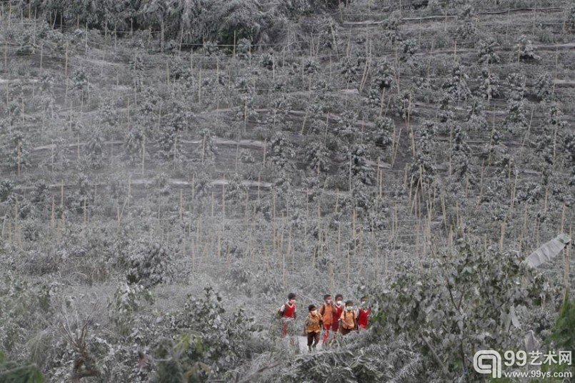 锡纳朋火山(Mount Sinabung)再度喷发后,数千人被迫离开家园。图为孩子们穿过布满火山的旷野从学校返回。