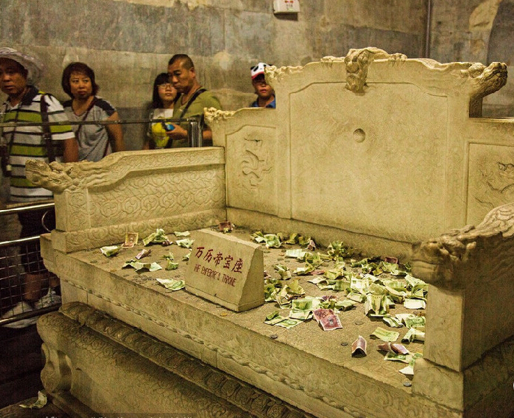 2014年8月14日,北京昌平区,5A级景区明十三陵定陵地宫内,历史文物上游客祈福所投过去的钱币堆成了小山,没有工作人员制止清理。