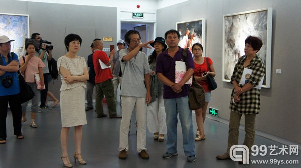 活动现场艺术家在给嘉宾导览讲解作品
