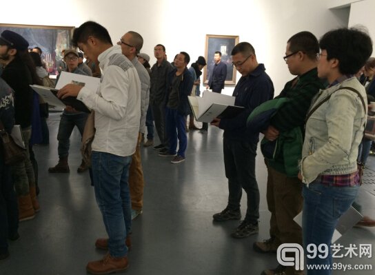 展览开幕式现场，观众翻看于轶文画册。