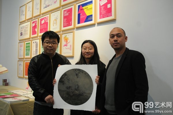 活动现场版画获奖者（中）与58艺术网执行总监罗忠学（左）及版画原作作者刘景弘（右）合影