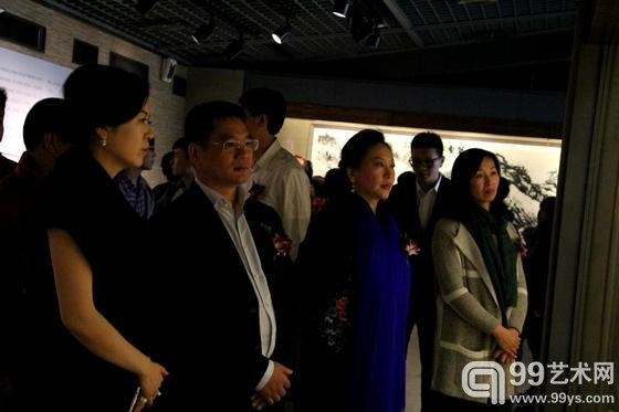 画家文蔚（左一）陪同嘉宾参观展览