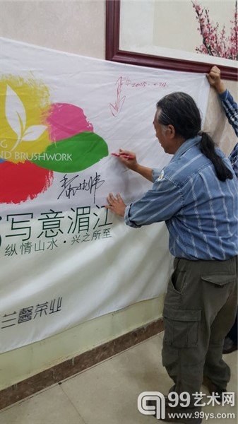 艺术家在活动海报上签名留念