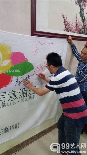 艺术家在活动海报上签名留念