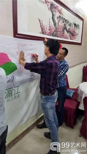 艺术家在活动海报上签名留念