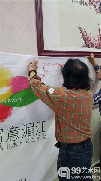 艺术家在活动海报上签名留念