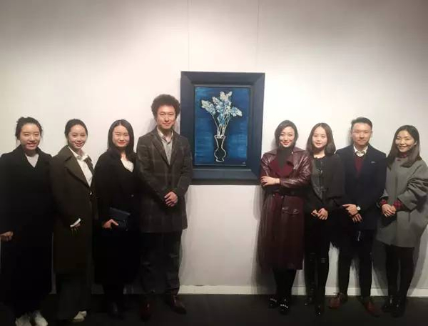 北京保利现当代艺术部门人员于常玉作品《蓝色背景的盆花》前合影