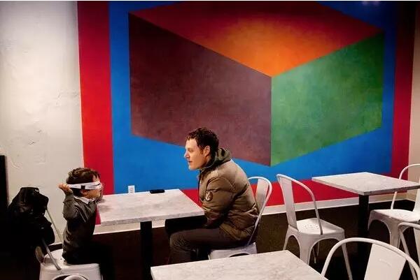 勒维特的另一件墙上绘画《Wall Drawing 620A》占据了学校咖啡厅的一面墙。Photo by Gillian Laub for The New York Times