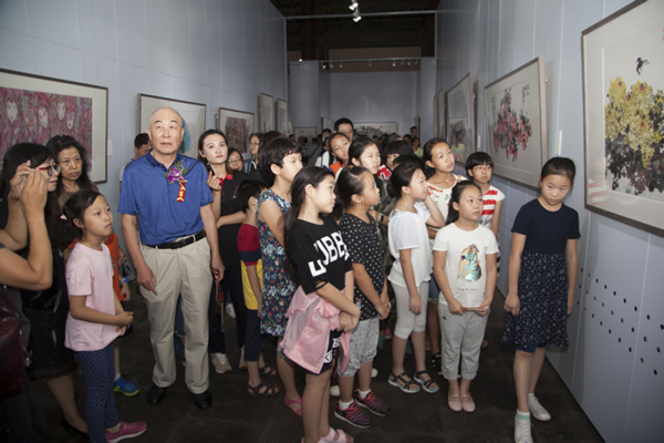 裴老在展厅带领观展团在展厅观展