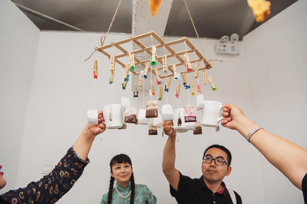 受邀嘉宾蓝兔子 郝立勋 举茶杯就茶包，泡开幕茶