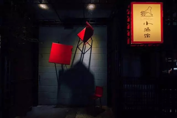 刘家琨将一组红色的桌椅挂在了小酒馆的外墙上