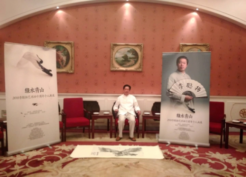 李聪扬在全国政协礼堂与其画作合影(贾敏/摄)