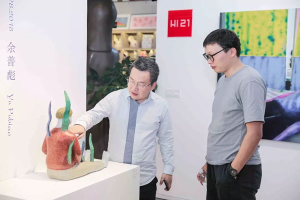 艺术家余普彪与友人在展览现场交流