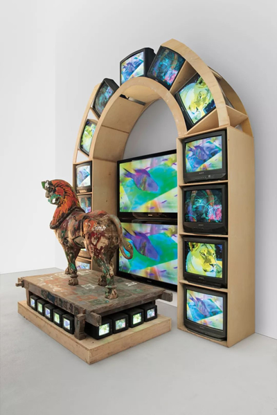 Nam June Paik, Lion, 2005, three-channel video (color, silent) with 2 plasma monitors, 26 CRT monitors, and wood lion with acrylic and permanent oil marker additions, 133 × 109 × 65 inches (337.8 × 276.9 × 165.1 cm). Photo: courtesy Nam June Paik Estate