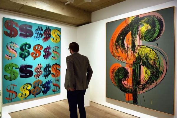 A visitor studies Andy Warhol, Dollar Signs, 1981, at Sotheby