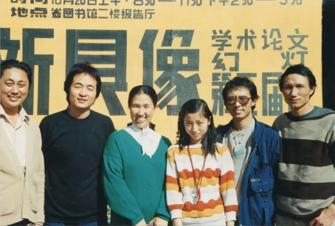 1986年10月26日“新具像（学术论文、作品幻灯）第三届展”，艺术家与单位领导合影。左起：何祥林、孙式范、马老师、何佳佳、张晓刚、毛旭辉。
