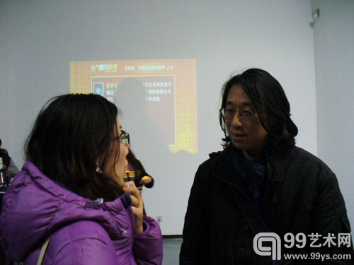 99艺术网上海站工作人员正与知名策展人王南溟亲密交流