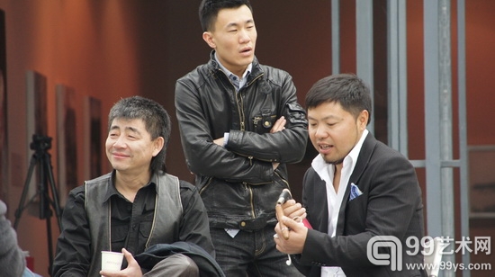 艺术家王劲松和杨冕坐在美术馆前晒太阳