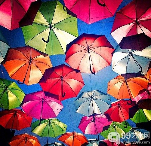 漫步在雨伞“天空”下，人们仿佛置身《爱丽丝梦游仙境》的奇妙世界。