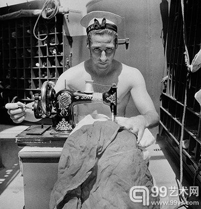 一个士兵正在用缝纫机修复一面旗帜