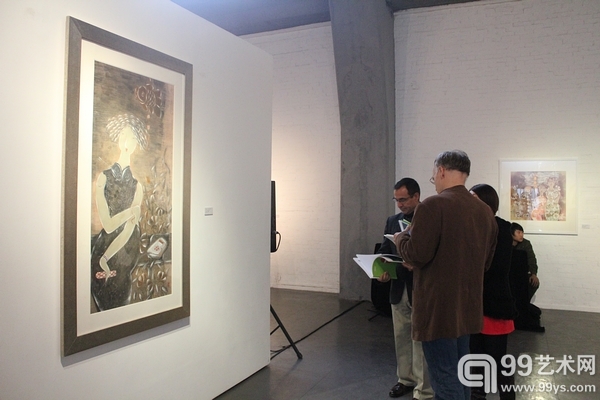 展览现场外国嘉宾翻阅画家展览画册