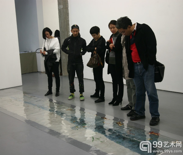 艺术家周轶伦（左二）为嘉宾介绍作品