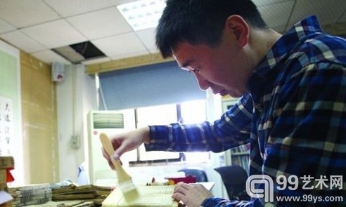 市博物馆，工作人员正小心翼翼扫去古籍上的灰尘。