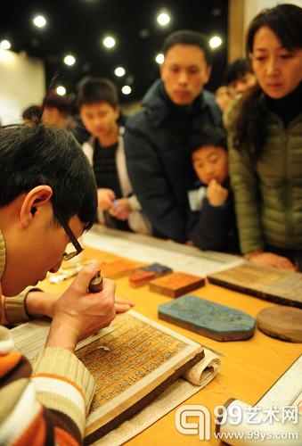 1月20日，参观者在辽宁珍贵古籍特展上观看工作人员雕版刻字