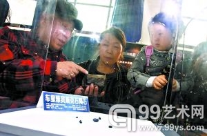 在“陨石与小行星展”上，北京天文馆的张宝林老师（左一）为参观者讲解今年坠落在俄罗斯的陨石