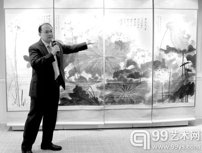 一名工作人员在香港佳士得预展会上介绍张大千大型立轴四幅重彩水墨画《荷塘野趣》。
