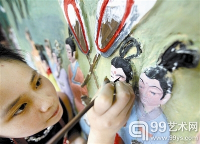 王茹军在小心翼翼地给人物画眉