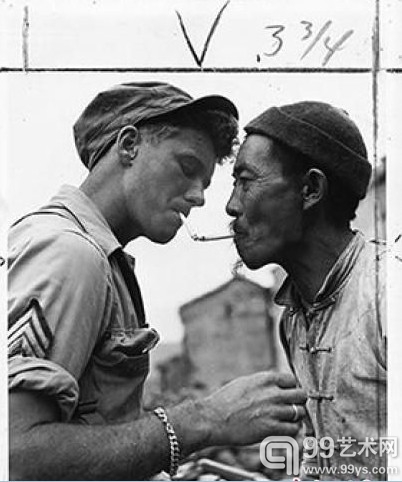 1944年10月14日，一位年长的中国男人在满目疮痍的云南那腾冲街头停下来，向一名美军军士借火，点燃他的烟锅。　资料图　摄