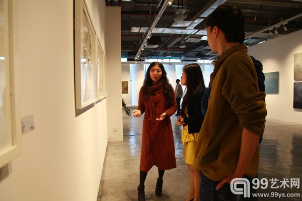艺术家王霄（左一）向观众讲解作品—摄影 谢木林