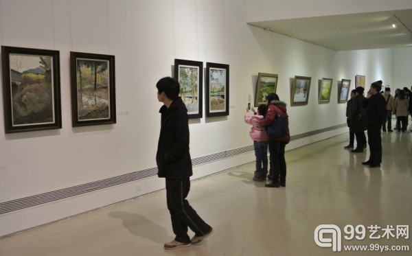 展览现场，观众正在欣赏油画作品。