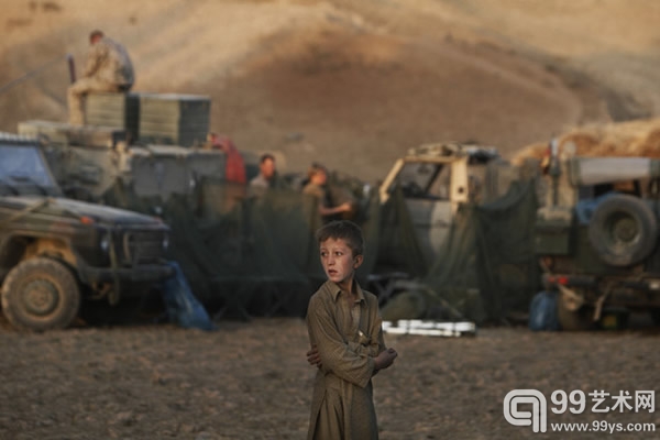 在阿富汗昆都士(Kunduz)东面的法扎巴德(Feyzabad)地区，巡逻的德国士兵正在准备临时帐篷，一个男孩驻足观看。照片拍摄于2009年9月。