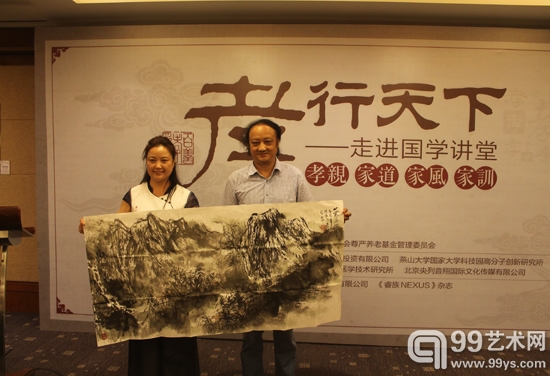 艺术家张贵成向“孝行天下——书画艺术巡回展”负责人刘晓华捐赠作品