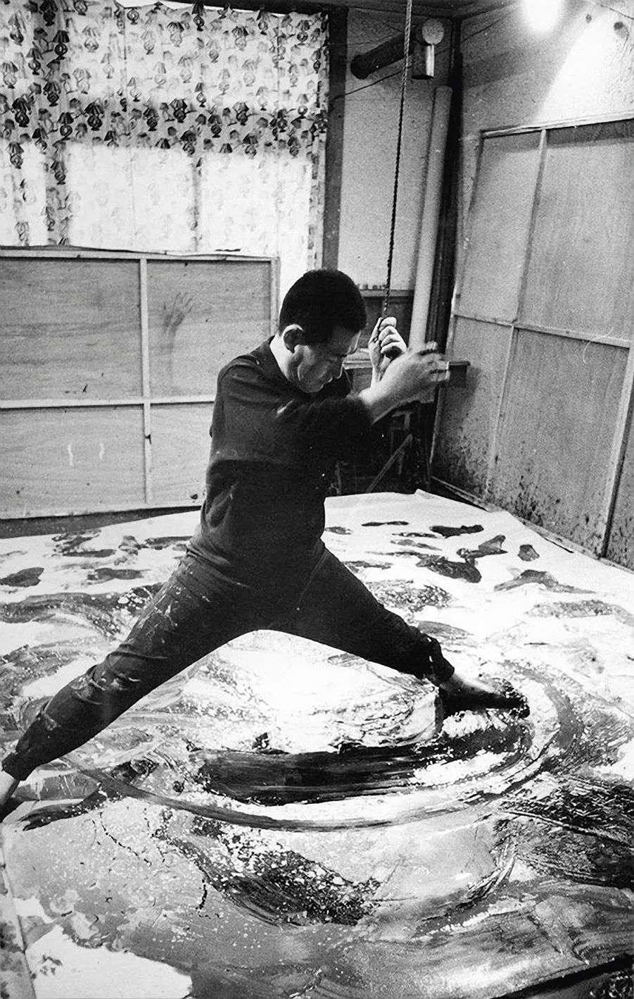 将自身悬吊、以足施力滑行作画的白发一雄，摄于1962年&copy;Courtesy Yukio Tahara/The Mainichi Newspapers/AFLO
