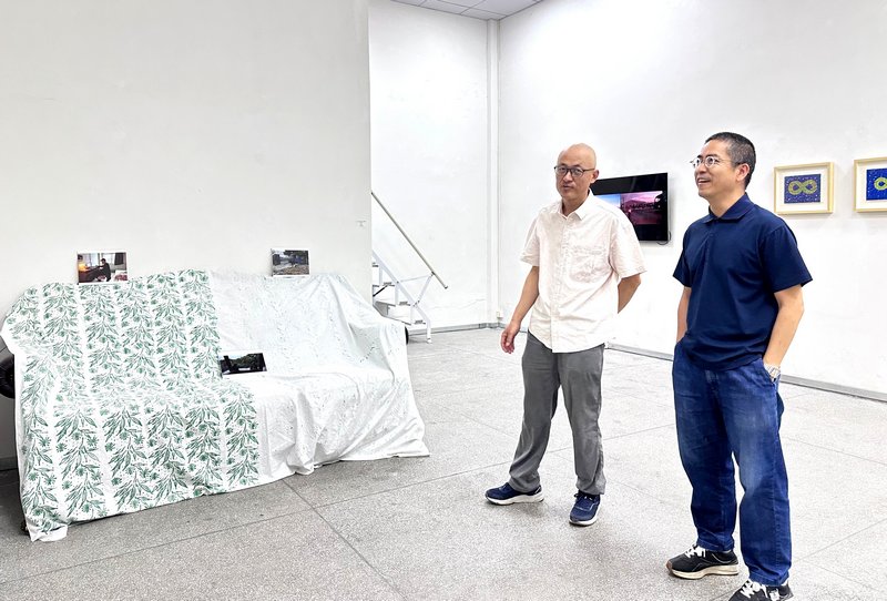 艺术家邓春儒在展览现场和黄文亚交流中